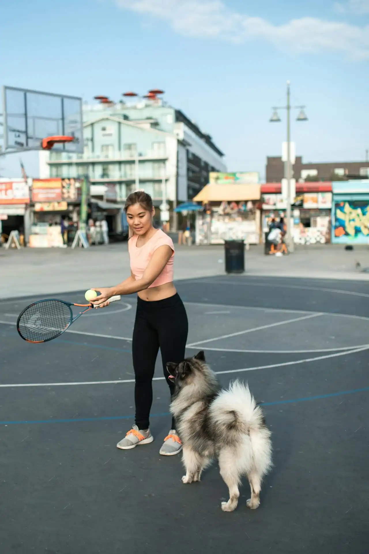 Female private tennis coach in Houston, Texas smiling at court, specializing in beginner and junior training.