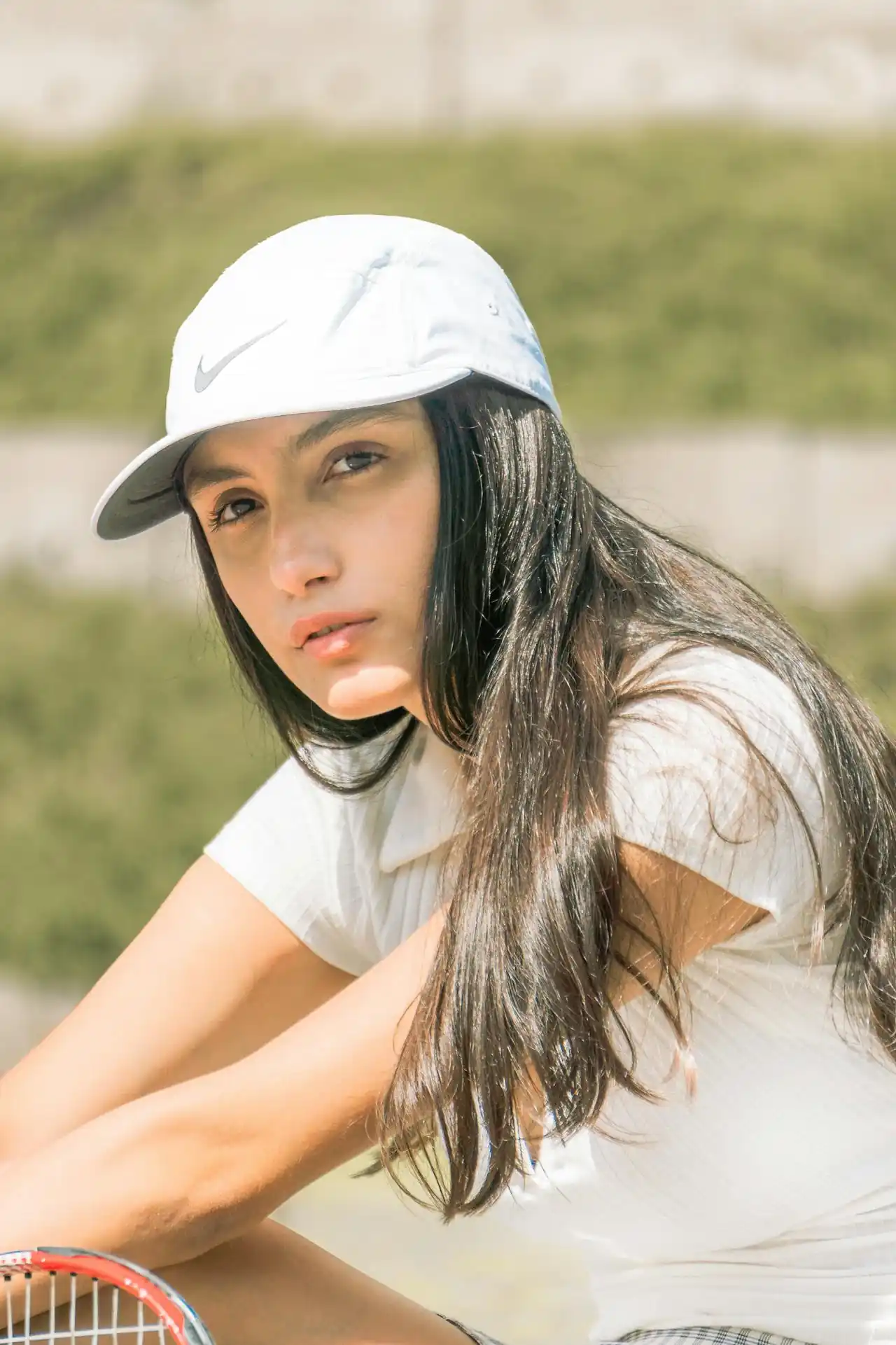 Female private tennis coach in West Palm Beach, Florida smiling at court, specializing in juniors and beginners