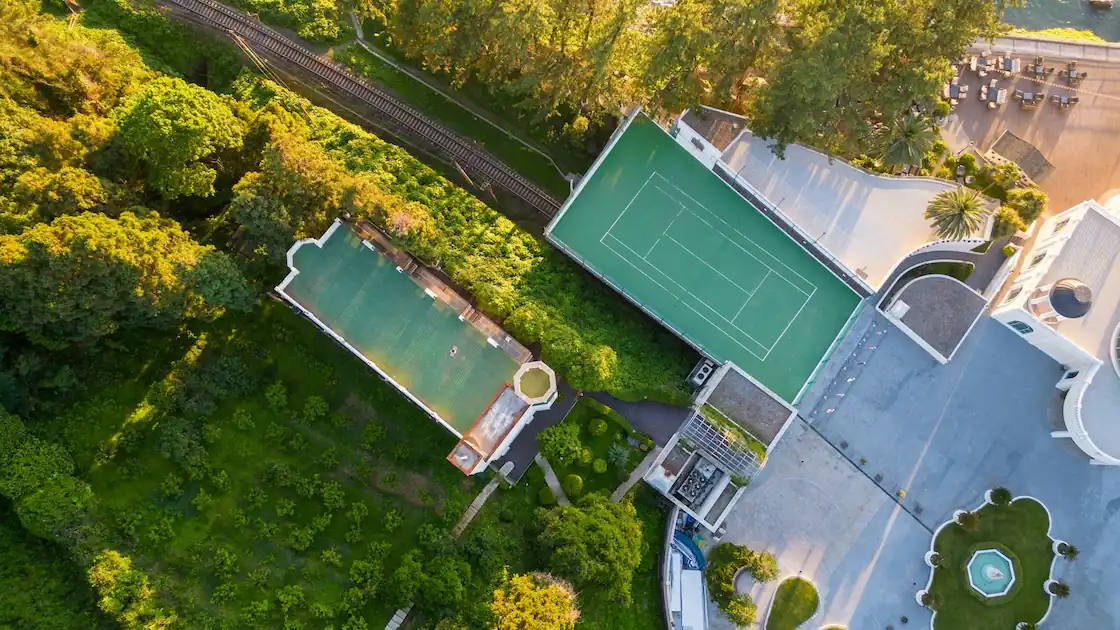 Aerial view of a luxury tennis facility in Frisco, TX showing pristine hard courts and clubhouse
