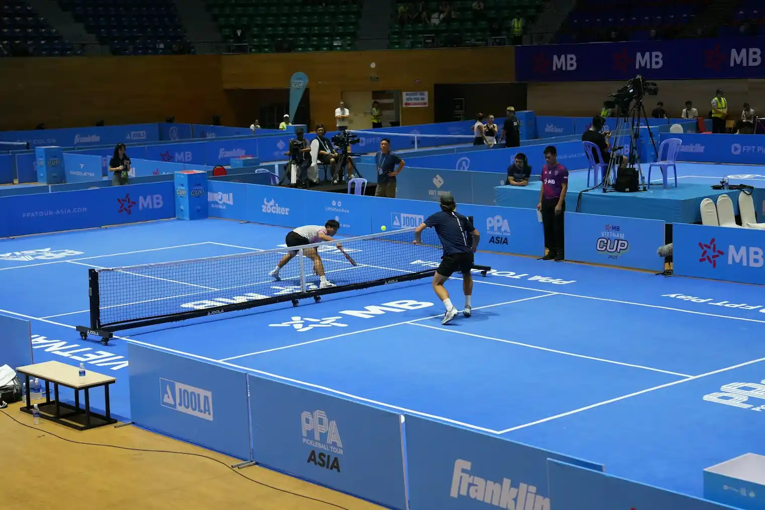 Players competing at a dedicated indoor pickleball facility in Frisco with professional lighting