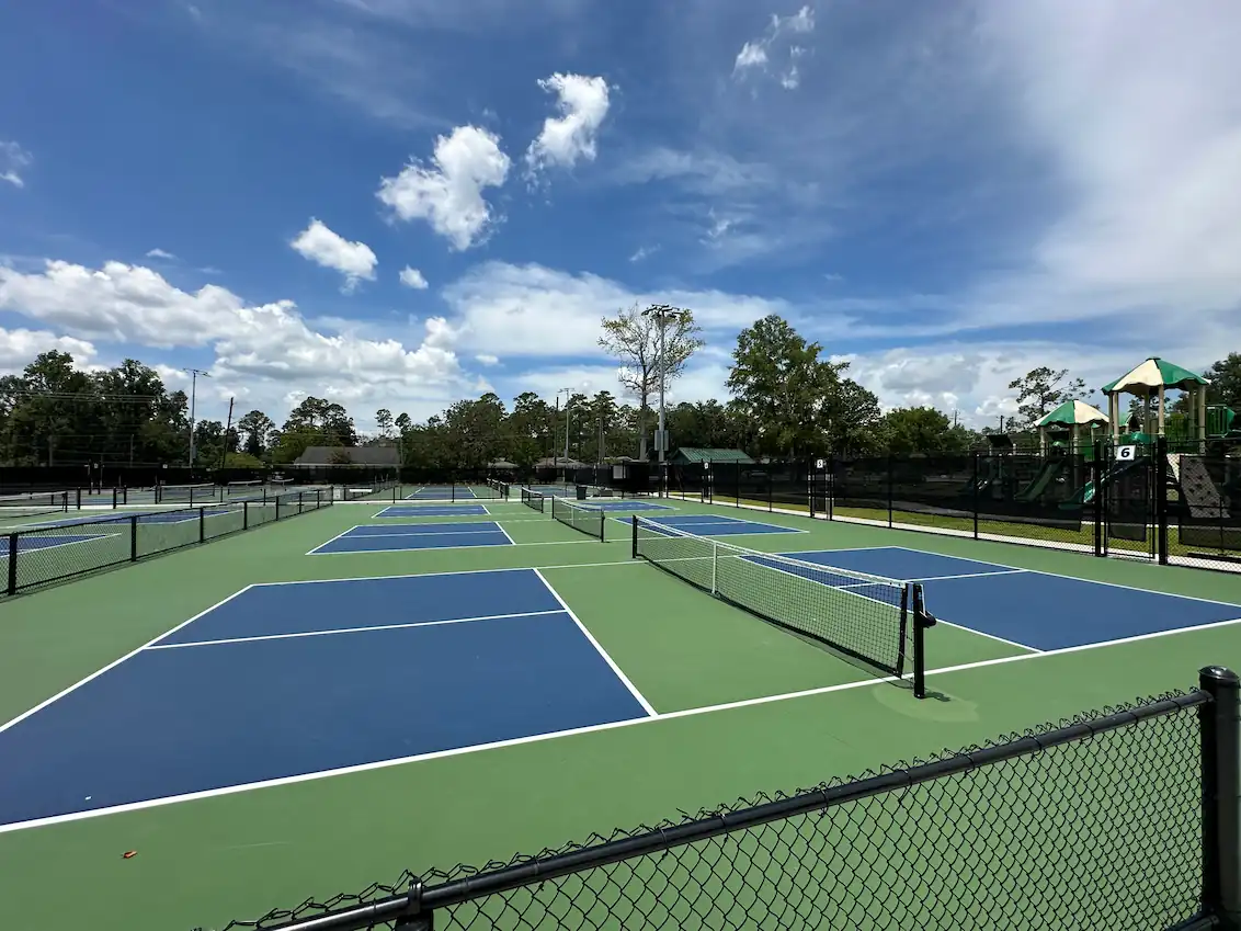 Side-by-side pickleball courts at a social venue in Arizona, featuring outdoor lighting and lounge areas