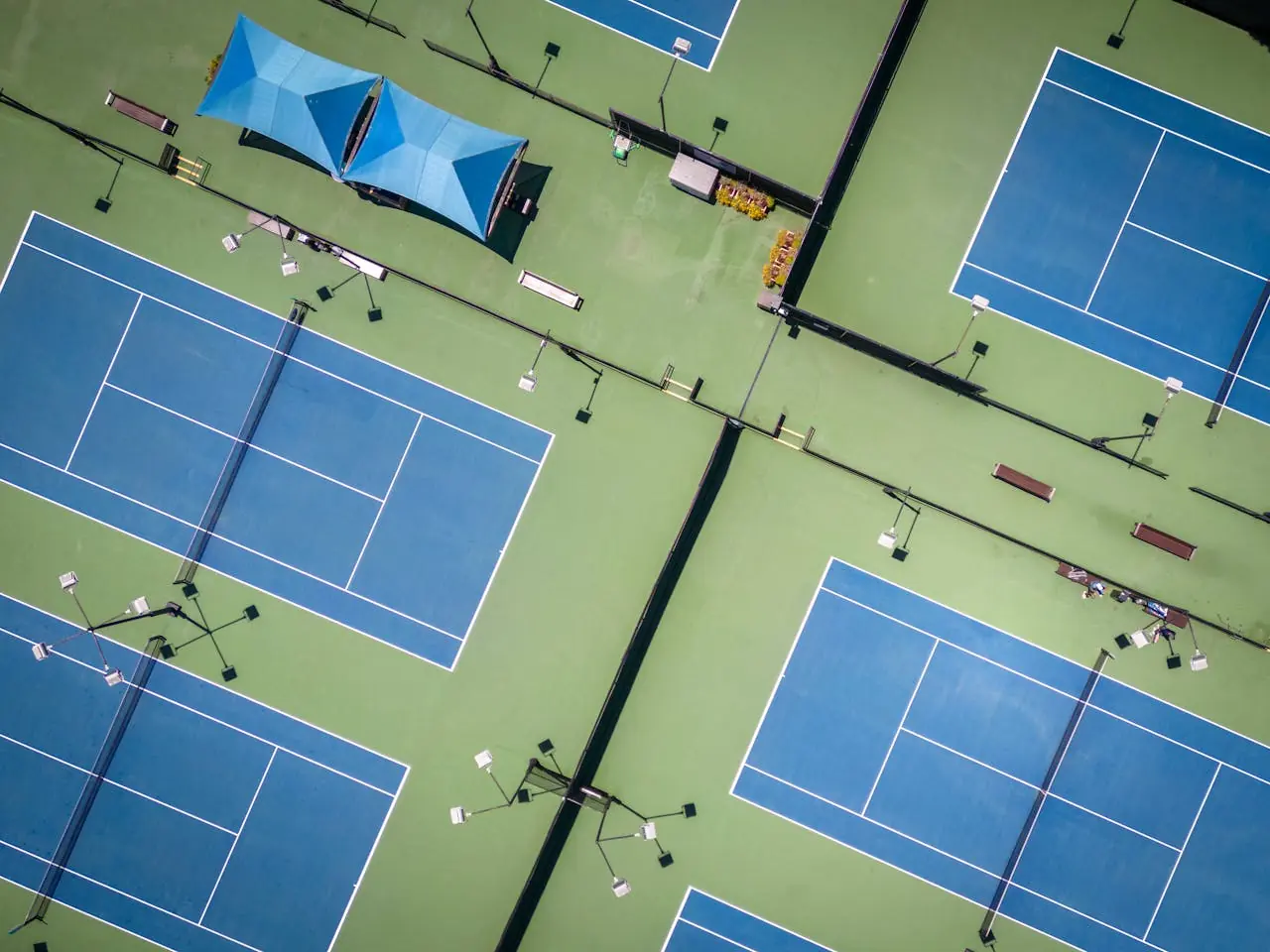 The dedicated pickleball courts at Delray Beach Tennis Center, showing the blue and green hard court surface