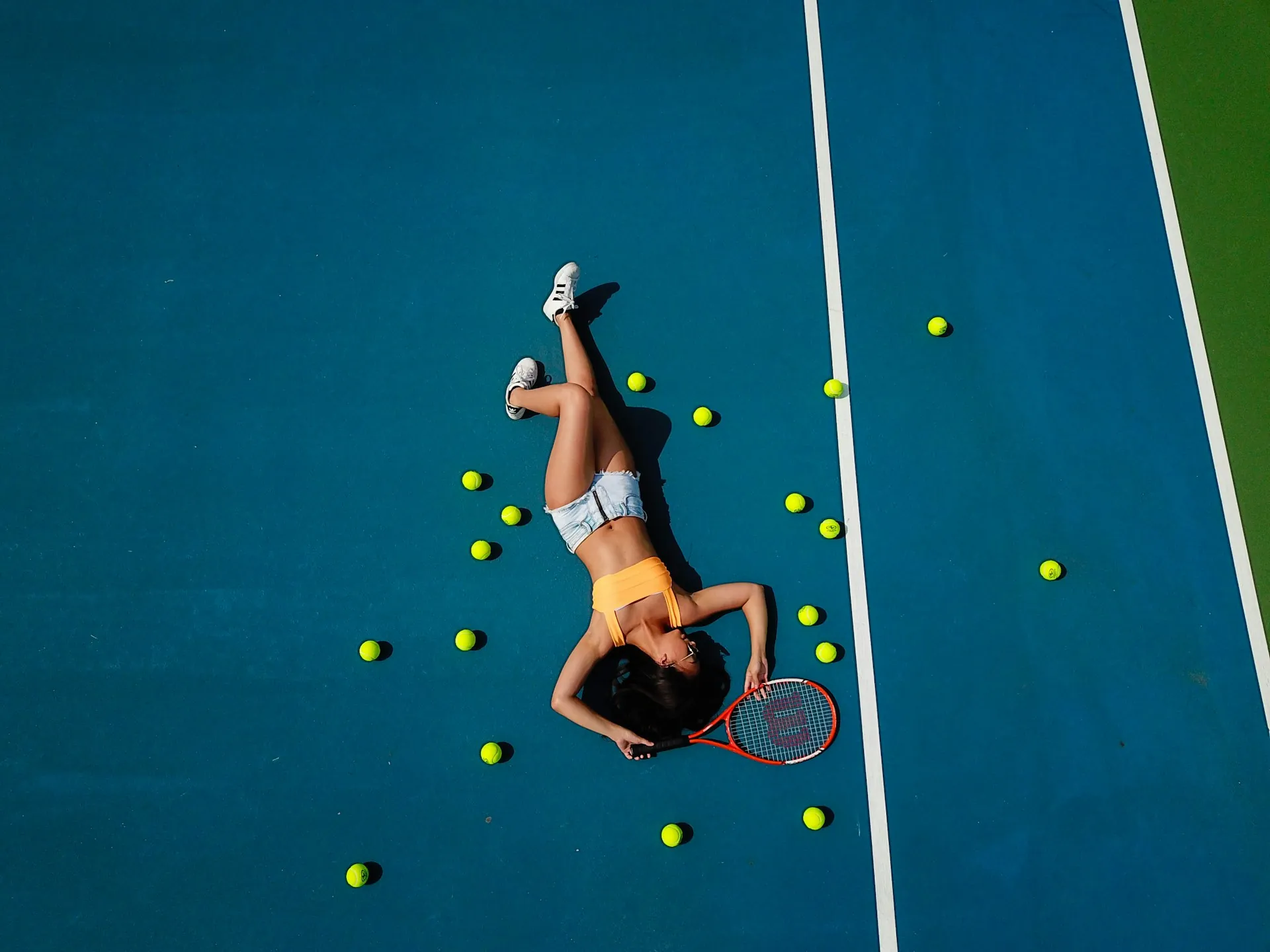 A tired but happy tennis player resting on a pristine hard court in Scottsdale after a long match