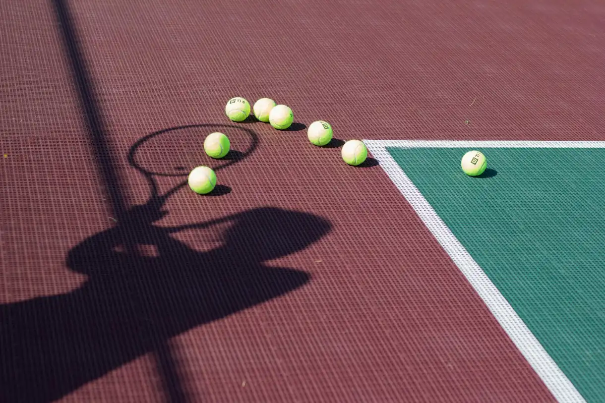 Tennis balls on an indoor hard court surface, safe from the Charlotte rain
