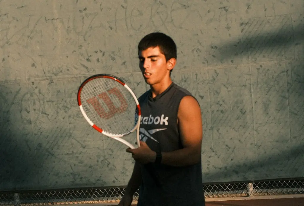 Coach Ethan reviewing his racquet during a private tennis lesson in Charlotte, NC.