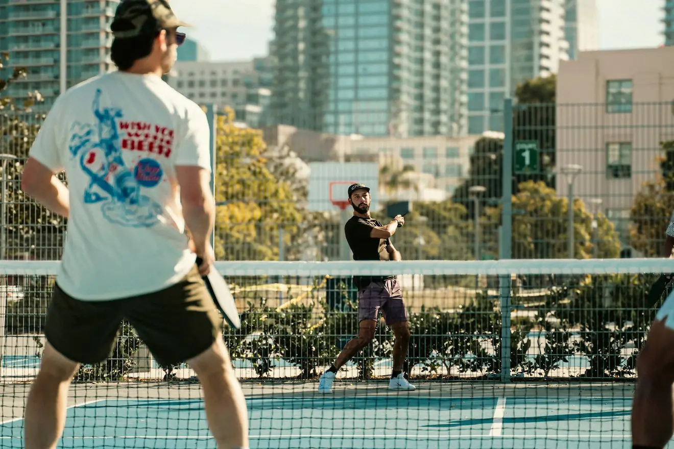Two players high-fiving mid-game during a premium corporate pickleball team building event in Bellevue, WA